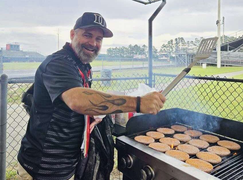 Pastor Tom helps make burgers in the concessions stand