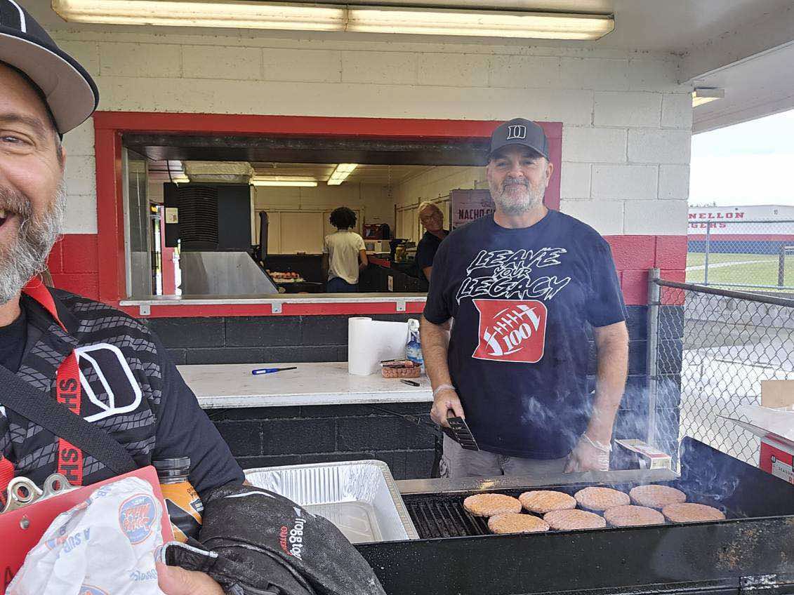 Volunteers cook up hamburgers at the concession stand