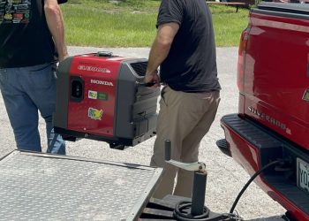 Pastor Tom and a Serve Team Volunteer unlead the generator to strt up the food truck