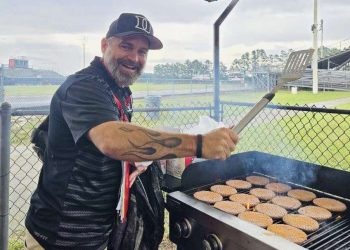 Pastor Tom helps make burgers in the concessions stand