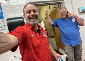 Pastor Tom stands with a DHS employee while he serves them free food