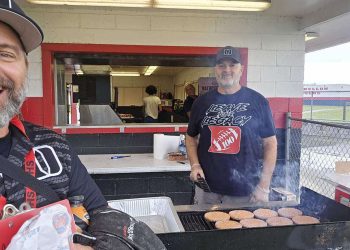 Volunteers cook up hamburgers at the concession stand